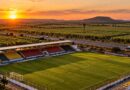 Estádio regional com cadeiras amarelas, vermelhas e pretas à beira de rodovia em Ceará-Mirim