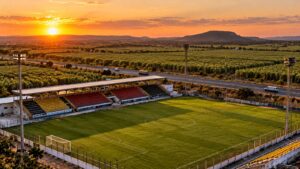 Estádio regional com cadeiras amarelas, vermelhas e pretas à beira de rodovia em Ceará-Mirim