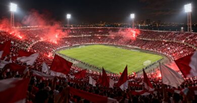 Torcida com bandeiras vermelhas e brancas em noite de jogo em estádio de Natal