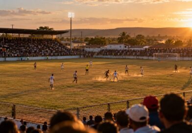 Partida de futebol em estádio regional brasileiro ao entardecer, com arquibancada cheia